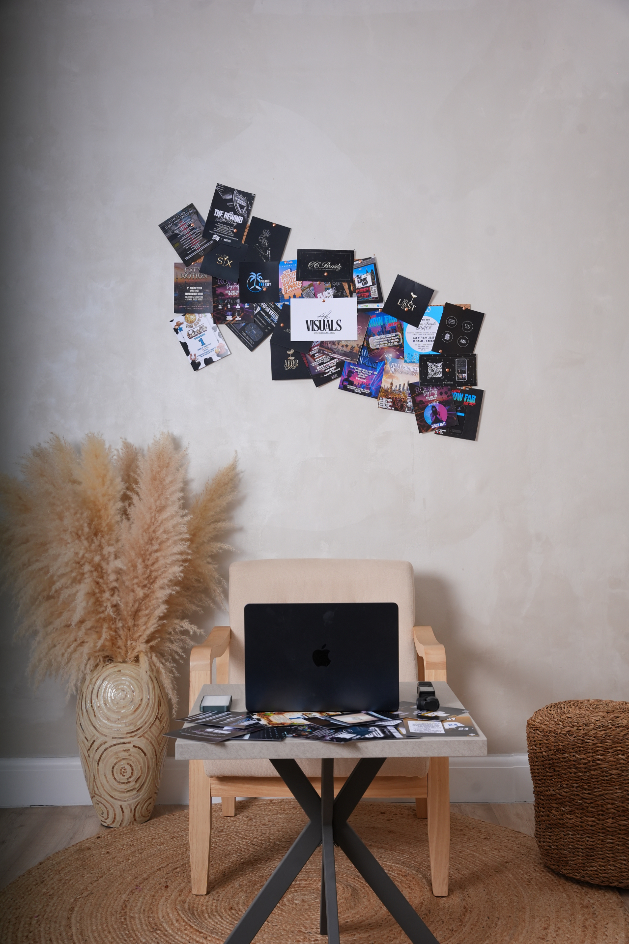 Wall mood board of pinned flyer designs behind a studio desk